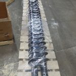 Long, metal augers on pallet wrapped on TAB Wrapper Tornado at Falcon Industries